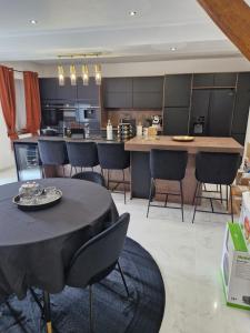 a kitchen with a table and chairs and a counter at Infinity marbre in Cérans-Foulletourte