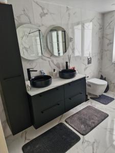 a bathroom with two sinks and two mirrors at Infinity marbre in Cérans-Foulletourte