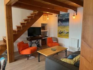 a living room with a couch and orange chairs at AN GOVEL in Crozon
