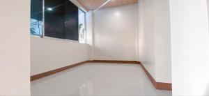 a room with a white wall and a window at Pacific Paradise Guesthouse in Ubay