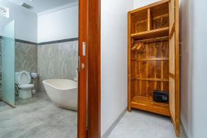 a bathroom with a tub and a sink and a toilet at Villa Made Ubud in Ubud