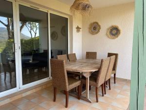 una sala da pranzo con tavolo e sedie in legno di Appartement Restanques du Golf de Saint Tropez 2 chambres 6 personnes a Grimaud