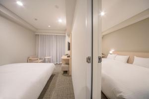 Ένα ή περισσότερα κρεβάτια σε δωμάτιο στο Sotetsu Fresa Inn Kyoto-Hachijoguchi +40 φωτογραφίες