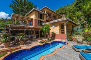 a house with a swimming pool in front of it at Pousada Bahia Bella in Morro de São Paulo
