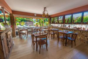 a restaurant with tables and chairs and a bar at Pousada Bahia Bella in Morro de São Paulo