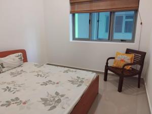 a bedroom with a bed and a chair and a window at The Enclave in Polgasowita