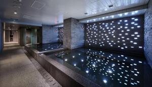 a pool of water in a building with lights on the wall at Grand Hyatt Taipei in Taipei