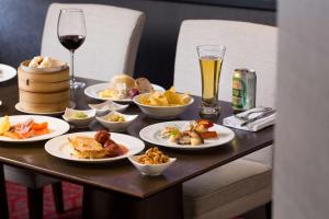 a table with plates of food and a glass of wine at Grand Hyatt Taipei in Taipei