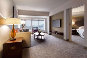 a hotel room with a couch and a bed and a television at Grand Hyatt Taipei in Taipei