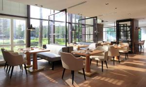 a restaurant with tables and chairs and large windows at Grand Hyatt Taipei in Taipei
