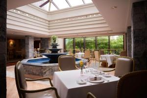 a dining room with a fountain and tables and chairs at Grand Hyatt Taipei in Taipei