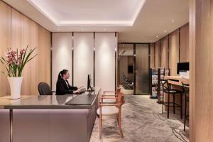 a woman sitting at a desk in an office at Grand Hyatt Taipei in Taipei