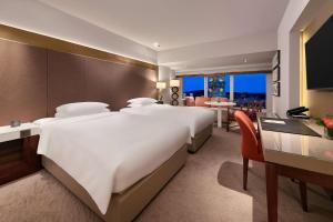 a large bedroom with a large white bed and a desk at Grand Hyatt Taipei in Taipei