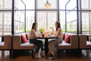 two women sitting at a table in a restaurant at Grand Hyatt Taipei in Taipei