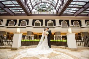 a bride and groom kissing in the lobby of a building at Grand Hyatt Taipei in Taipei