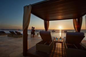 a balcony with a view of the ocean at sunset at Divi Flamingo Beach Resort in Kralendijk