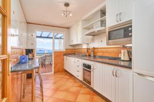 a kitchen with white cabinets and a counter top at Casa Maritima in La Herradura