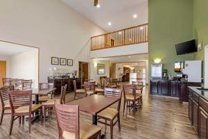 a restaurant with tables and chairs and a kitchen at Sleep Inn & Suites Charles City in Charles City