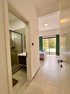 a bathroom with a walk in shower and a sink at Coastal View 2 Apartments North in Grand Baie