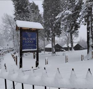 a sign in a park covered in snow at Braemar Lodge Cabins Not for profit in Braemar