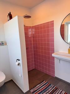 a bathroom with a pink tiled shower and a sink at Panoramic Holiday Apartment - Dagmar in Ebeltoft +10 photos
