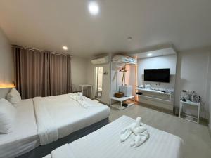 a hotel room with two beds and a flat screen tv at Bed By Boat @Nonthaburi Pier in Nonthaburi +43 photos