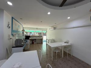 a kitchen with white tables and chairs in a room at Bed By Boat @Nonthaburi Pier in Nonthaburi