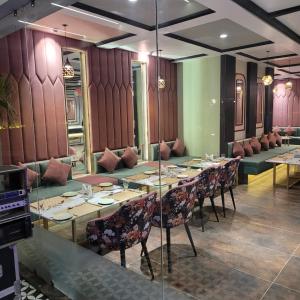 a dining room with a long table and chairs at Country Green Hotel & Banquet in Bareilly