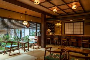 a restaurant with tables and chairs and a bar at 岩井温泉　岩井屋 in Iwamicho
