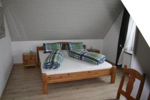 a bed with four pillows on it in a room at Frey - Ferienhaus über zwei Etagen mit Terrasse in Eggebek