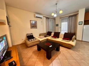 Una sala de estar con dos sofás y un televisor. en Guest Grand House, en Tirana