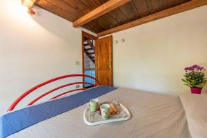 a bed with a tray of food and two cups on it at Apartment in San Teodoro 23143 in San Teodoro