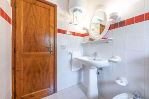 a bathroom with a sink and a wooden door at Apartment in San Teodoro 23144 in San Teodoro +12 photos