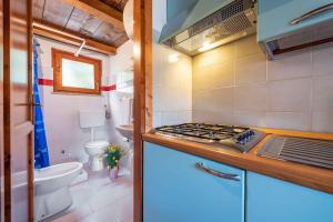 a small kitchen with a stove and a toilet at Apartment in San Teodoro 23143 in San Teodoro