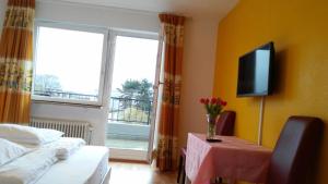 a room with a bed and a table and a television at Hotel Adler in Grenzach-Wyhlen