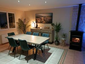 a dining room with a table and a fireplace at Maison OPTIKU CORMEILLES in Cormeilles