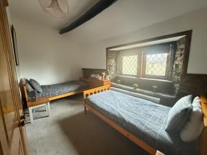 a bedroom with two beds and a window at 2Bed Cottage - Trawden - Pet Friendly - Sleeps4 in Colne