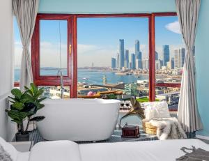 FushansuoQingdao Shanhaiji Sea View B&B Wusi Square Branch的带浴缸的大窗户