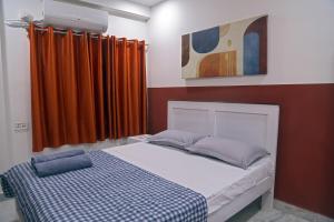 a bed in a room with orange curtains at Royal Residency 3BHK -II in Kondapur