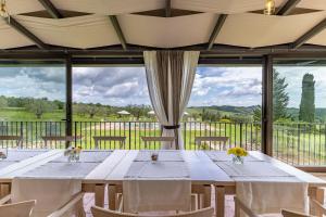 Un comedor con una mesa y un gran ventanal. en Villa Demetra, en Sarteano