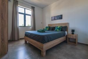 a bedroom with a bed with blue sheets and a window at Cozy Penthouse - Near restaurants and beaches in Grand Baie +15 photos