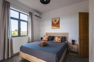 a bedroom with a bed with a teddy bear on it at Cozy Penthouse - Near restaurants and beaches in Grand Baie