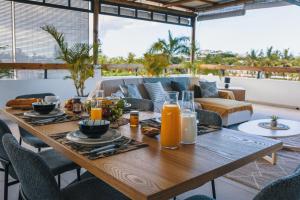 a table with food and orange juice on a patio at Cozy Penthouse - Near restaurants and beaches in Grand Baie