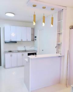 a white kitchen with white cabinets and a sink at Stylish Condominium in Puerto Princesa near PPS Airport in Puerto Princesa City