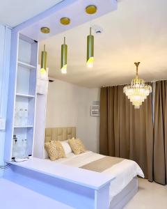 a bedroom with a bed and a chandelier at Stylish Condominium in Puerto Princesa near PPS Airport in Puerto Princesa City