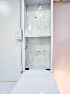 a cabinet filled with wine glasses in a refrigerator at Stylish Condominium in Puerto Princesa near PPS Airport in Puerto Princesa City