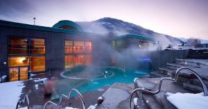 a building with a swimming pool in the snow at Le Nomézia in Ax-les-Thermes