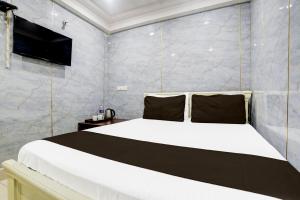 a bedroom with a large white bed and a tv at Spot On Sri Balaji in Vijayawāda