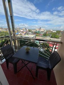 a table and chairs on a balcony with a view at SM Naga City 2BR River view Balcony with Fiber Internet in Naga