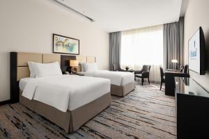 Postel nebo postele na pokoji v ubytování Cristal Hotel Abu Dhabi